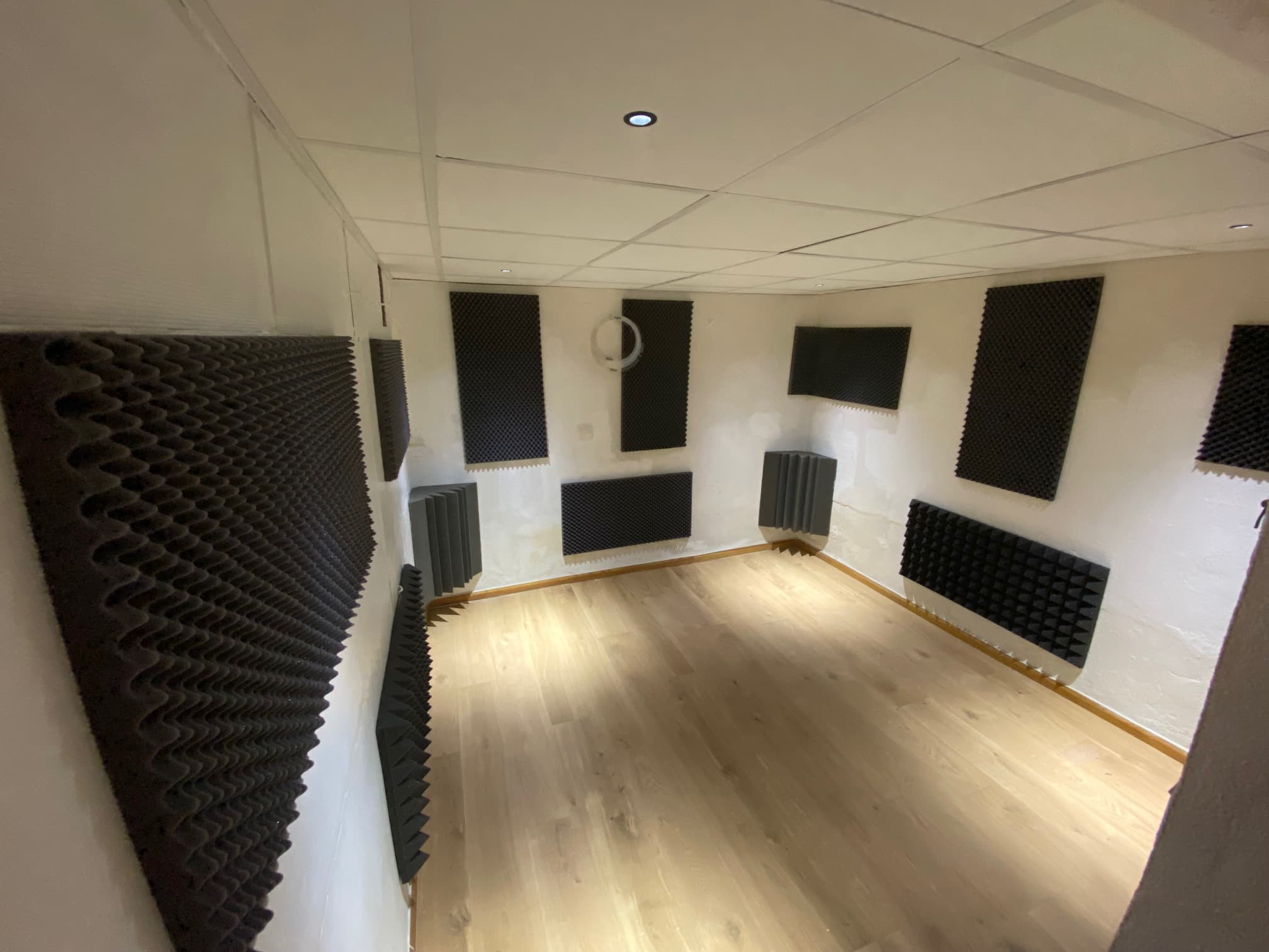 La cabine de prise du studio, murs traités avec des panneaux acoustiques en mousse et parquet clair